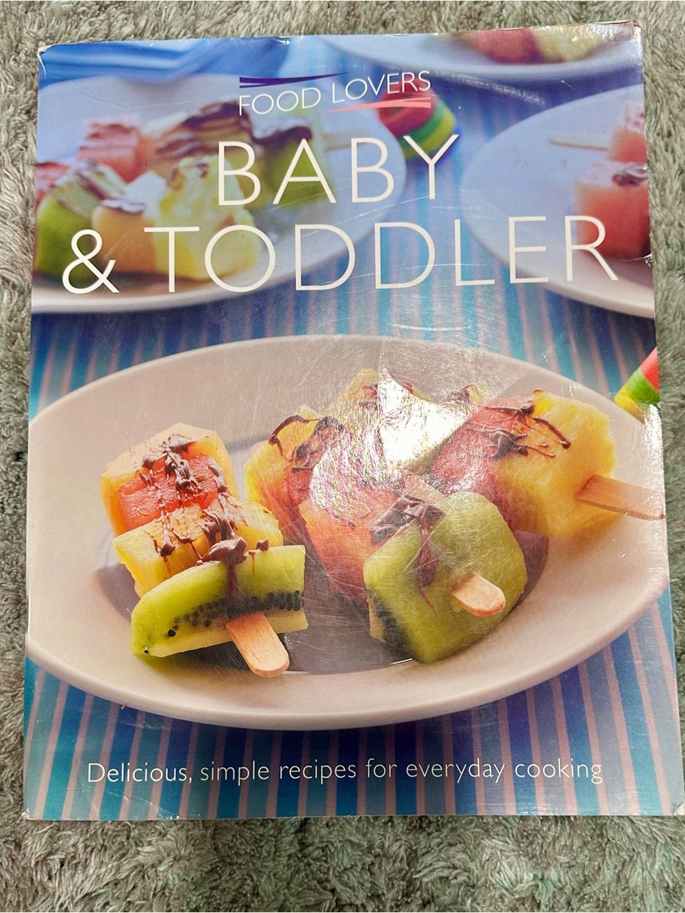 Food Lovers Baby & Toddler Cookbook - Blue Cover with Fruit Skewer Image